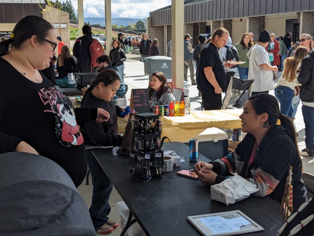 Oyemutne Ramirez and Zachariahs Ramirez browse a booth run by Joselyn Kelley, right, at Big Time on Thursday, March 28, 2024 in Butte Valley, California. (Jake Hutchison/Enterprise-Record)
