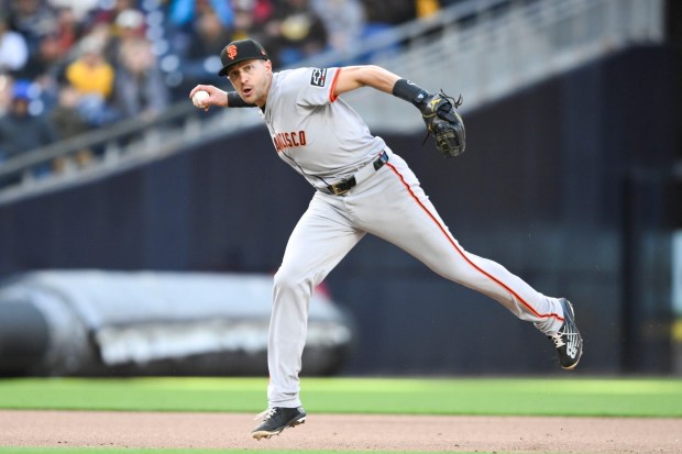 San Francisco Giants shortstop Nick Ahmed throws San Diego Padres' Fernando Tatis Jr. out at first base during the fifth inning of a baseball game, Saturday, March 30, 2024, in San Diego. (AP Photo/Denis Poroy)