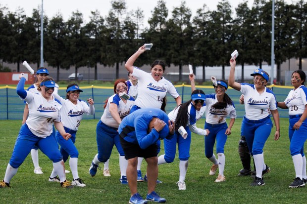 Mt. Eden High School softball players throw their wristbands to head coach Derrick Blue as they celebrate their win against San Leandro High School on Thursday, March 28, 2024, in San Leandro, Calif. Mt. Eden won the game 8-3. (Dai Sugano/Bay Area News Group)