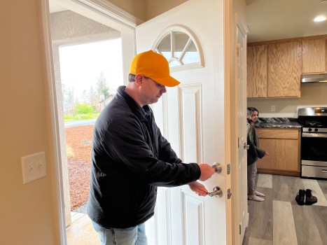 Paradise new homeowner Benny Hawthorne opens the door to his brand new home built as part of the Community Housing Improvement Program self-help homeownership program Friday, March 29, 2024 in Paradise, California. (Jennie Blevins/Enterprise-Record)