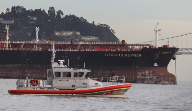 The Overseas Reymar, which struck the southwest tower of the Oakland-San Francisco Bay Bridge, is seen at anchor near Treasure Island as a Coast Guard vessel passes by in San Francisco, Calif. on Monday, Jan. 7, 2013. (Jane Tyska/Staff Archives)