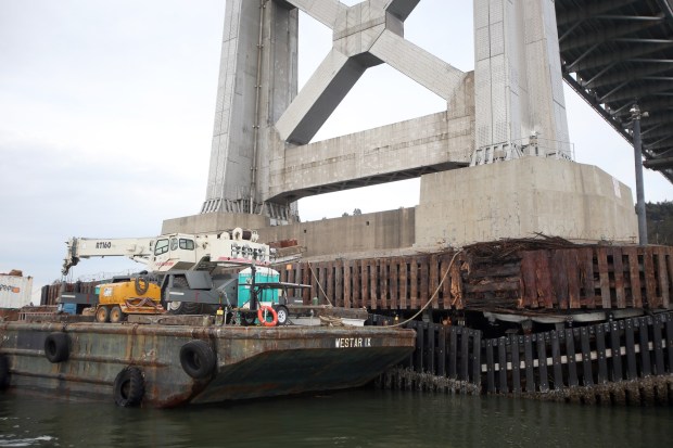 A barge filled with equipment is tethered to a tower of the Oakland-San Francisco Bay Bridge just west of Treasure Island in San Francisco, Calif., on Tuesday, Jan. 22, 2013. Repair to the tower began on Tuesday after the tanker ship Overseas Reymar hit the bridge on Jan. 7. (Jane Tyska/Staff)