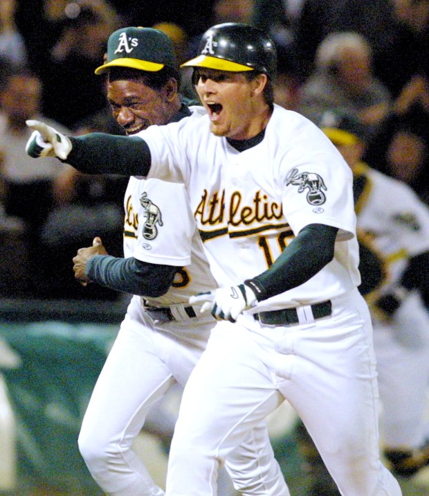 Third base coach Ron Washington congratulates Scott Hatteberg after his game-winning homer in the ninth inning to beat the Kansas City Royals 12-11, on Wednesday, Sept. 4, 2002 in Oakland, Calif. The A's broke the American League record with their 20th consecutive win. (Nick Lammers/Bay Area News Group)