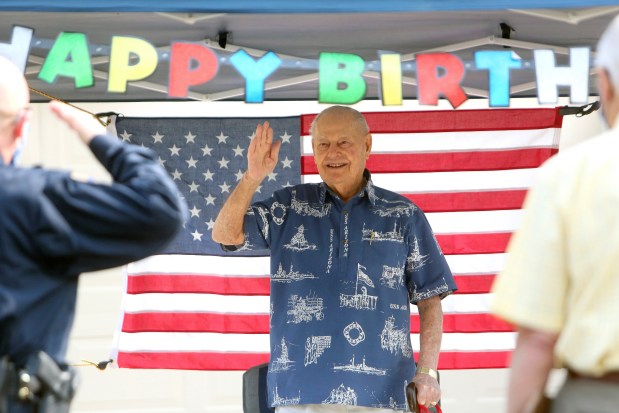 FILE - WWII Veteran and USS Arizona survivor Lou Conter waves as visitors salute in honor of his 99th birthday in front of his home in Grass Valley, Calif., Sept. 12, 2020. Conter, the last living survivor of the USS Arizona battleship that exploded and sank during the Japanese bombing of Pearl Harbor, died on Monday, April 1, 2024, following congestive heart failure, his daughter said. He was 102. (Elias Funez/The Union via AP, File)